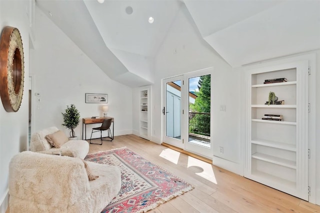 24 Maple St, Steamboat Springs, CO 80487 - living area featuring built in shelves, light wood-style floors, baseboards, and high vaulted ceiling
