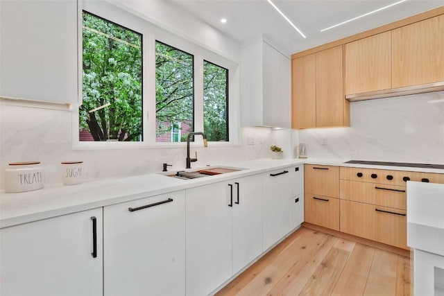 24 Maple St, Steamboat Springs, CO 80487 - kitchen featuring a sink, tasteful backsplash, stovetop, light wood finished floors, and light countertops