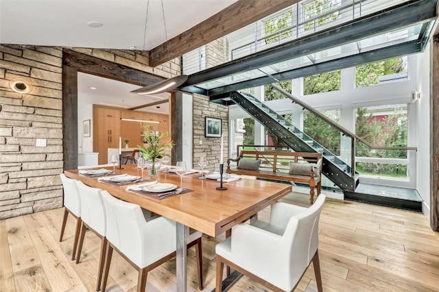 24 Maple St, Steamboat Springs, CO 80487 - dining space featuring a towering ceiling, healthy amount of natural light, wood-type flooring, wooden walls, and stairs