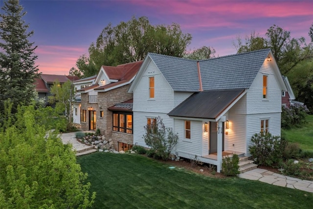 24 Maple St, Steamboat Springs, CO 80487 - view of front of house featuring a front lawn, metal roof, and stone siding