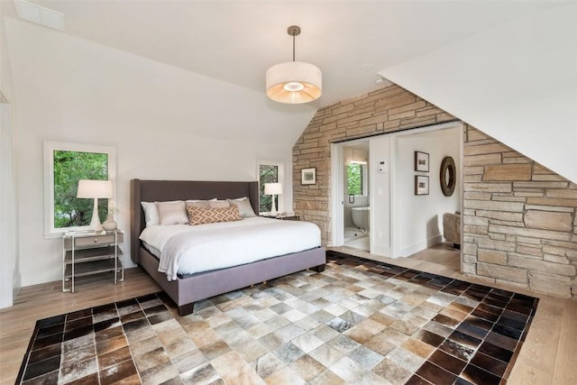 24 Maple St, Steamboat Springs, CO 80487 - bedroom with vaulted ceiling, wood finished floors, and ensuite bathroom