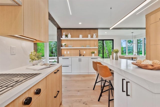24 Maple St, Steamboat Springs, CO 80487 - kitchen featuring stainless steel gas cooktop, modern cabinets, light wood-style floors, light brown cabinets, and recessed lighting
