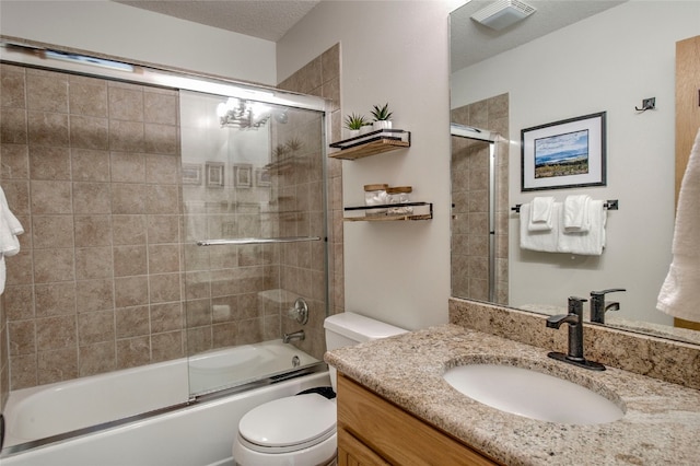 bathroom featuring a textured ceiling, bath / shower combo with glass door, toilet, visible vents, and vanity