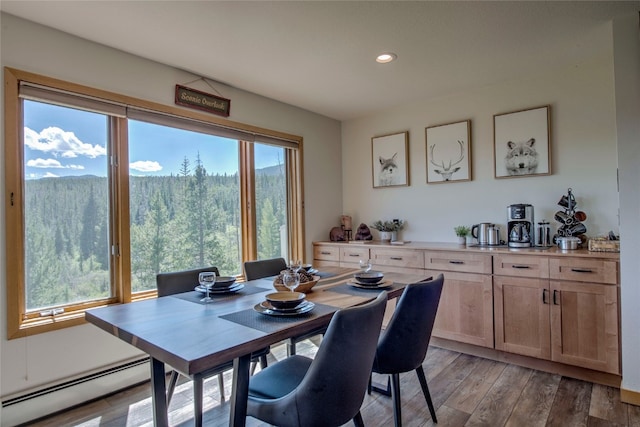 dining area with a baseboard radiator, light wood-style floors, and recessed lighting