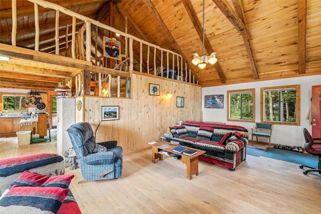 389 Routt Forest Loop, Craig, CO 81625 - living area featuring a wooden ceiling with exposed beams, healthy amount of natural light, wood-type flooring, a chandelier, and wood walls