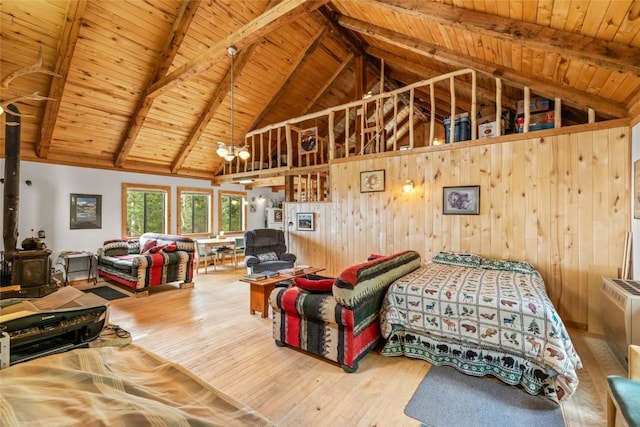 389 Routt Forest Loop, Craig, CO 81625 - bedroom featuring a wooden ceiling with exposed beams, wooden walls, wood finished floors, high vaulted ceiling, and a wood stove