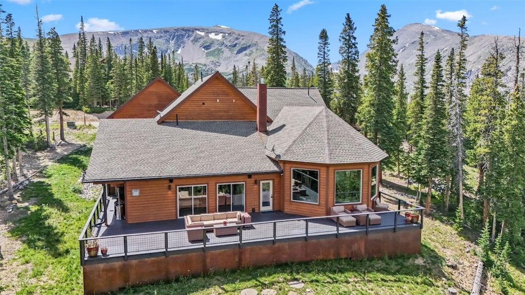 384 Camron Ln, Breckenridge, CO 80424 - rear view of property featuring outdoor lounge area, a mountain view, roof with shingles, and a wooded view
