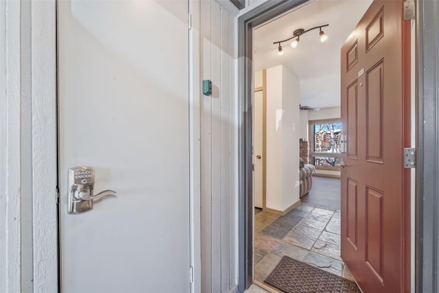 bathroom featuring stone tile flooring and baseboards