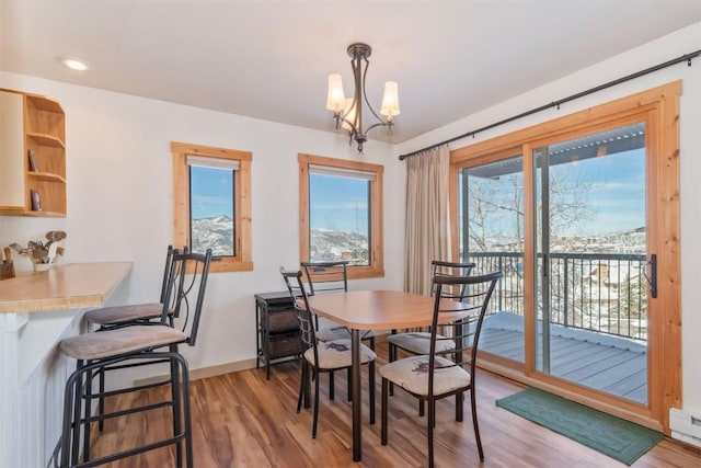 dining space featuring light wood-style flooring, a chandelier, baseboards, and recessed lighting