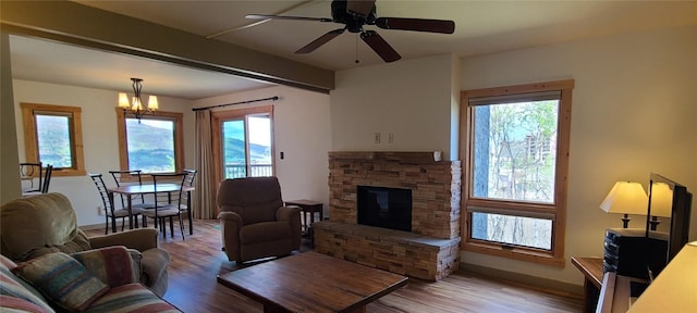 2590 Longthong Rd Unit 211, Steamboat Springs, CO 80487 - living room featuring wood finished floors, healthy amount of natural light, a stone fireplace, and a chandelier