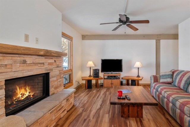 living room with wood finished floors, a fireplace, ceiling fan, and baseboards