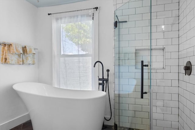 225 N Poplar St, Hayden, CO 81639 - bathroom featuring a stall shower, a soaking tub, and baseboards