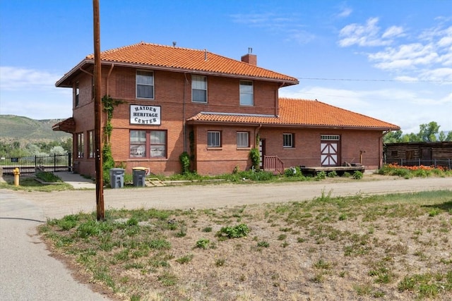 225 N Poplar St, Hayden, CO 81639 - back of property with a tile roof, a chimney, central AC, and a mountain view
