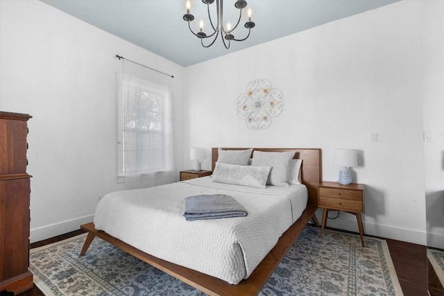 225 N Poplar St, Hayden, CO 81639 - bedroom featuring a chandelier, baseboards, and wood finished floors