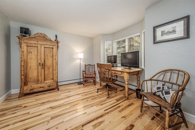 home office with light wood-style flooring, baseboards, and a baseboard radiator