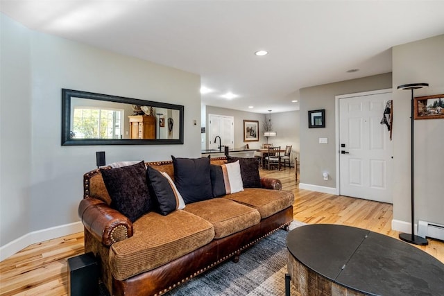 living area featuring baseboards, recessed lighting, and light wood-style floors
