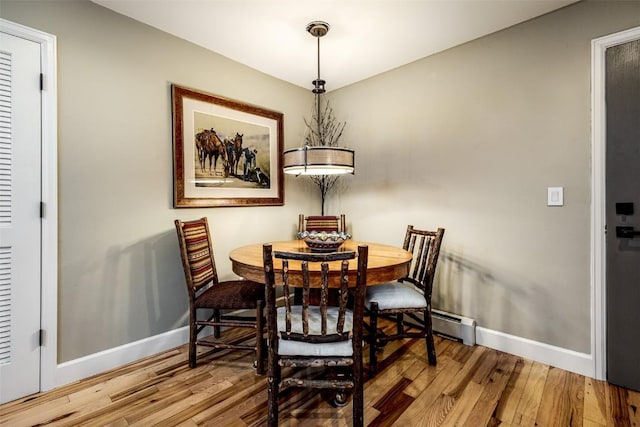 dining area with baseboards and wood finished floors