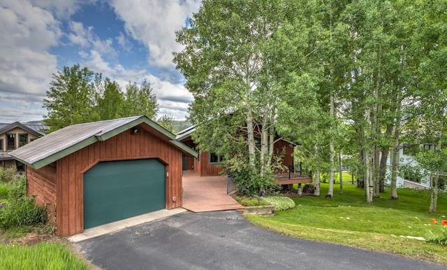 1763 Brome Dr, Steamboat Springs, CO 80487 - view of front of house featuring a front lawn, a detached garage, and metal roof
