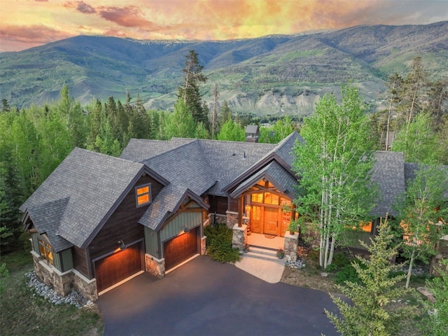 460 Two Cabins Dr, Silverthorne, CO 80498 - view of front facade with stone siding, roof with shingles, asphalt driveway, a mountain view, and a chimney
