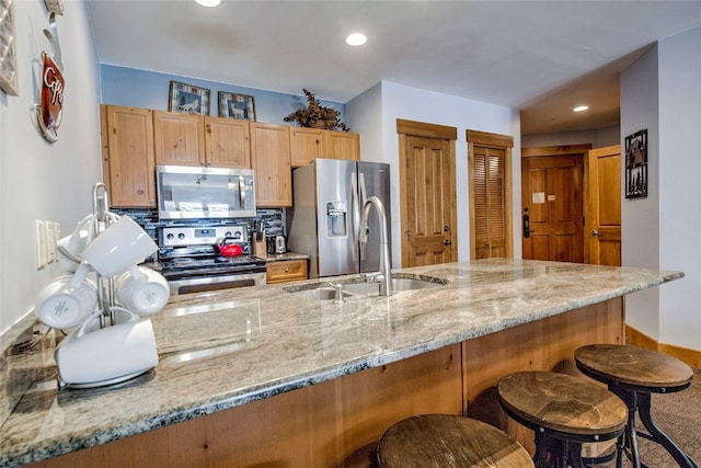 53 Hunki Dori Ct Unit 8863, Keystone, CO 80435 - kitchen featuring stainless steel appliances, a kitchen bar, a sink, light stone counters, and recessed lighting