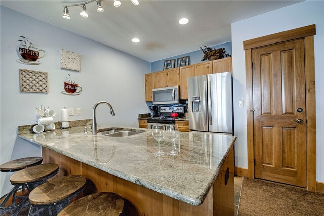 53 Hunki Dori Ct Unit 8863, Keystone, CO 80435 - kitchen with stainless steel appliances, a sink, a peninsula, light stone countertops, and a kitchen breakfast bar