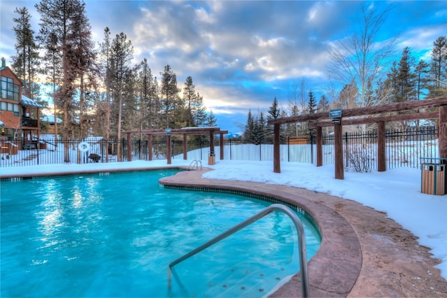 snow covered pool featuring fence and a community pool