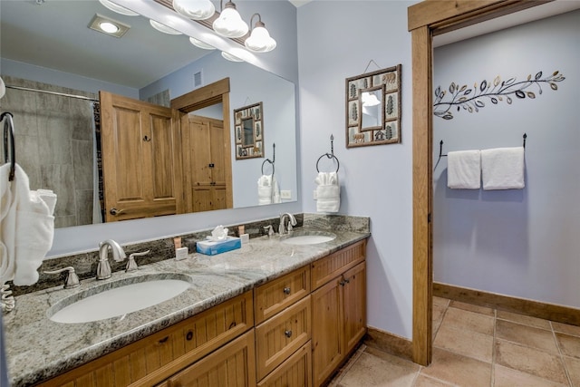full bathroom with double vanity, baseboards, and a sink