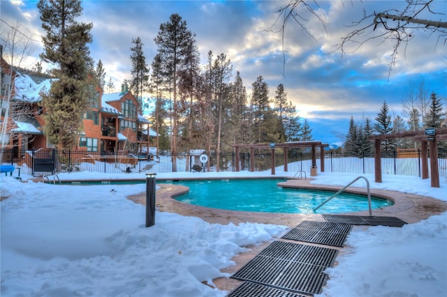 snow covered pool featuring fence and a community pool