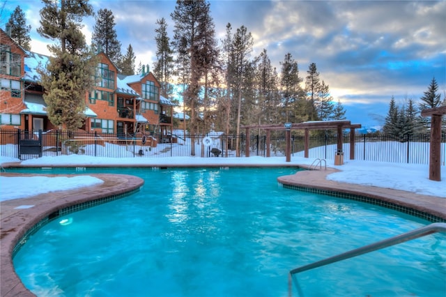 snow covered pool with a community pool and fence