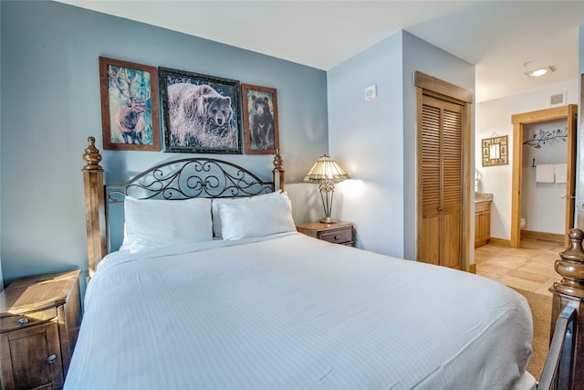 bedroom featuring a closet, visible vents, baseboards, and light tile patterned floors
