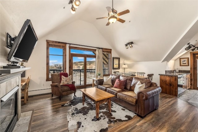 505 S Main St Unit 2207, Breckenridge, CO 80424 - living area featuring a fireplace, a baseboard radiator, wood finished floors, lofted ceiling, and a ceiling fan