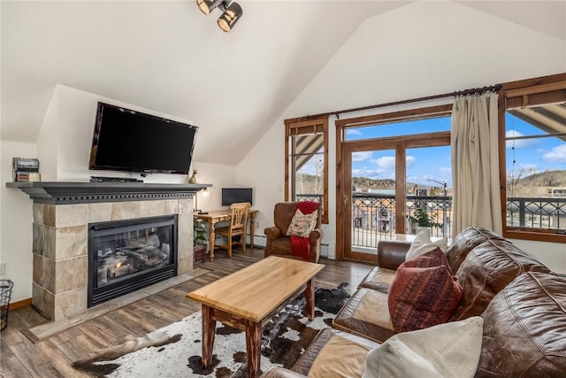 505 S Main St Unit 2207, Breckenridge, CO 80424 - living room featuring lofted ceiling, a tiled fireplace, wood finished floors, baseboards, and a baseboard radiator