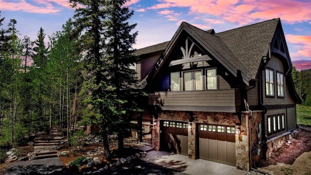 862 Penstemon Rd, Keystone, CO 80435 - rustic home featuring an attached garage, driveway, stone siding, and a shingled roof