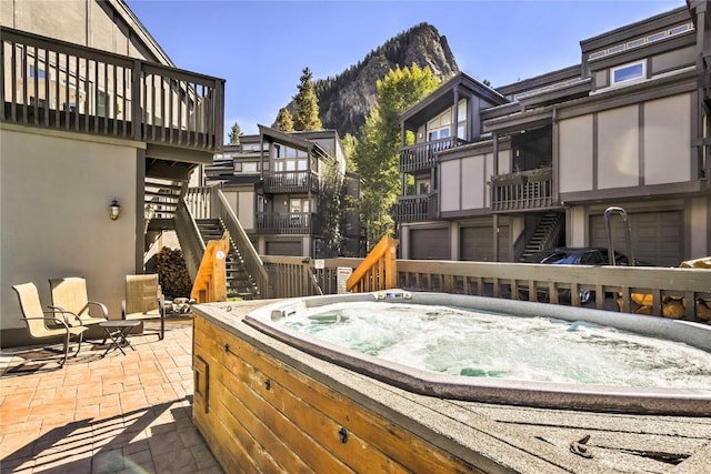 233 Creekside Dr Unit 104, Frisco, CO 80443 - wooden terrace featuring an outdoor hot tub, stairs, a mountain view, a patio area, and a garage