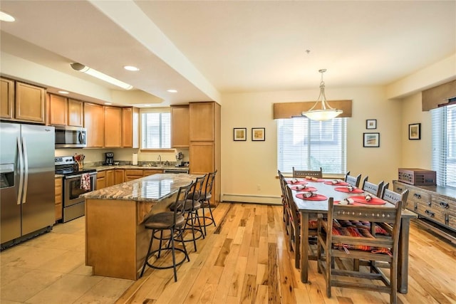 233 Creekside Dr Unit 104, Frisco, CO 80443 - kitchen with a center island, stone countertops, stainless steel appliances, a kitchen breakfast bar, and recessed lighting