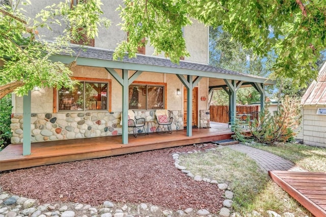 424 3rd St, Steamboat Springs, CO 80477 - back of property featuring stucco siding, fence, a wooden deck, and stone siding