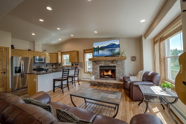 74 Stag Trl Unit 74, Dillon, CO 80435 - living area with light wood-style floors, a fireplace, recessed lighting, lofted ceiling, and a baseboard radiator