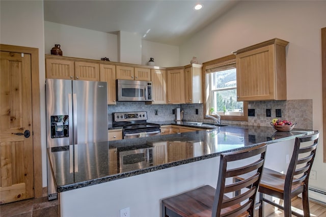 74 Stag Trl Unit 74, Dillon, CO 80435 - kitchen featuring stainless steel appliances, light brown cabinets, decorative backsplash, a kitchen bar, and dark stone countertops