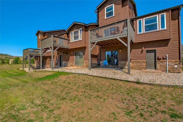 74 Stag Trl Unit 74, Dillon, CO 80435 - back of property featuring stone siding, a deck, a lawn, and a patio area