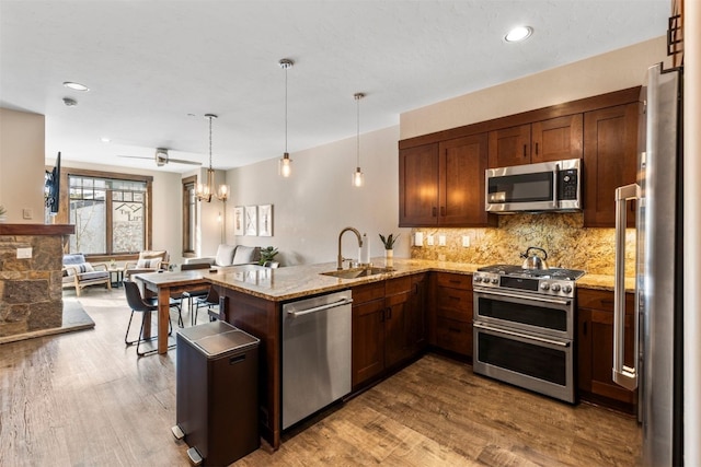 600 Columbine Rd Unit 5306, Breckenridge, CO 80424 - kitchen featuring appliances with stainless steel finishes, a sink, a peninsula, light stone countertops, and decorative backsplash