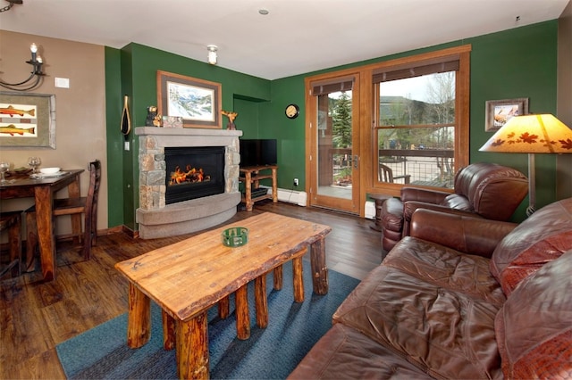 129 River Run Rd Unit 8040, Keystone, CO 80435 - living room featuring a stone fireplace, wood finished floors, baseboards, and baseboard heating