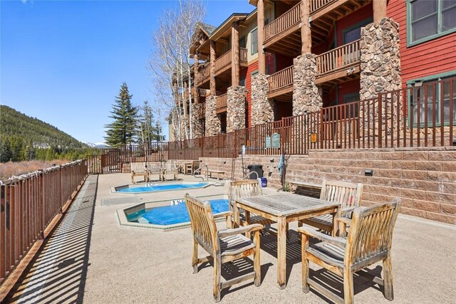 22714 US Highway 6 Unit 5941, Keystone, CO 80435 - view of swimming pool with outdoor dining area, a fenced backyard, a fenced in pool, a patio area, and a jacuzzi