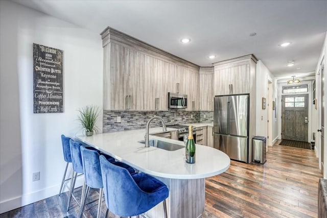 102 Lake Ridge Cir Unit 1888, Keystone, CO 80435 - kitchen featuring stainless steel appliances, light countertops, a kitchen bar, a peninsula, and backsplash