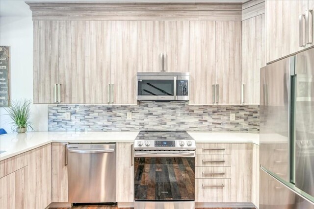 102 Lake Ridge Cir Unit 1888, Keystone, CO 80435 - kitchen with stainless steel appliances, modern cabinets, light brown cabinetry, light countertops, and decorative backsplash