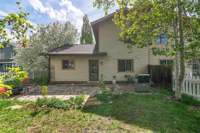 3432 Flagstone Ct, Steamboat Springs, CO 80487 - back of property featuring a fire pit, a patio area, and a shingled roof