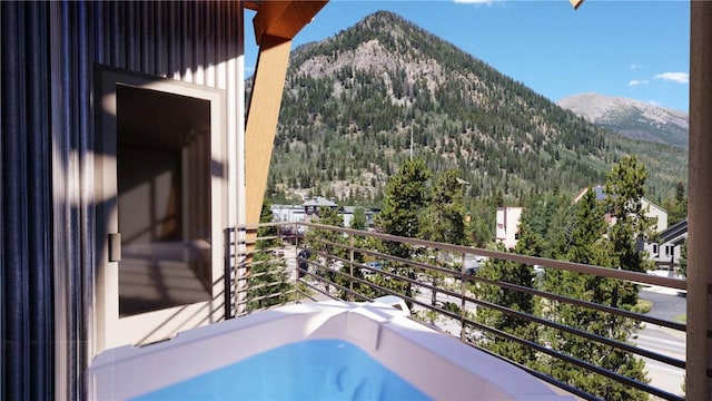 balcony featuring a mountain view and a view of trees