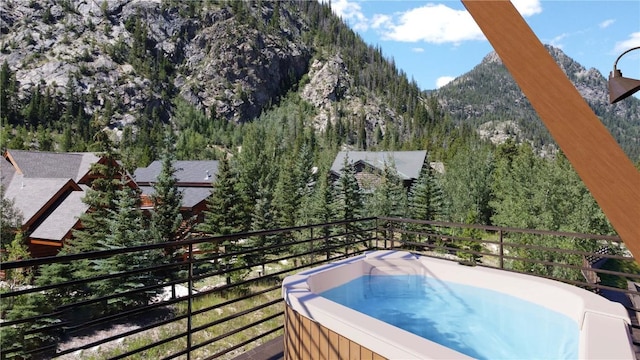 exterior space with a view of trees, a hot tub, and a mountain view