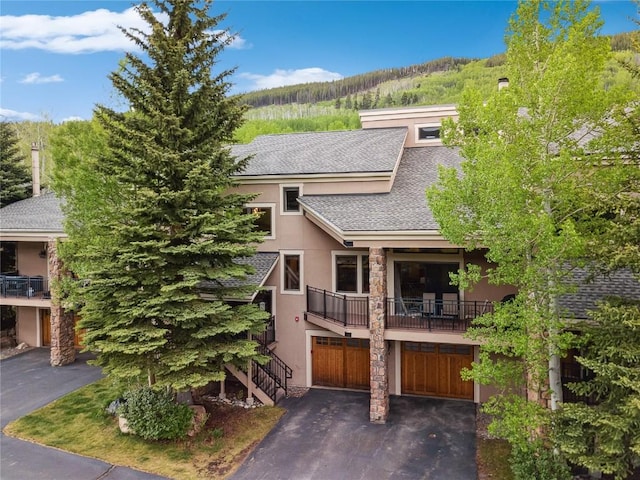 23177 Barbour Dr Unit 14, Keystone, CO 80435 - view of front facade with roof with shingles, stucco siding, driveway, a garage, and a balcony