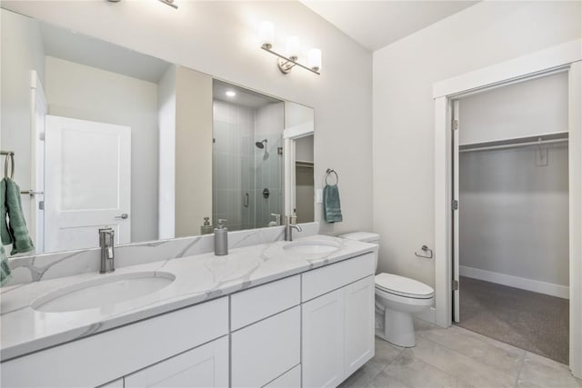 full bathroom featuring double vanity, a sink, a shower stall, and a walk in closet