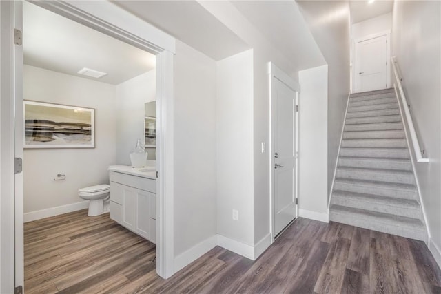 stairs featuring baseboards, wood finished floors, and visible vents